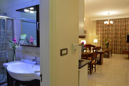 a bathroom with a sink and a dining room at Comfort Hotel Suites in Amman