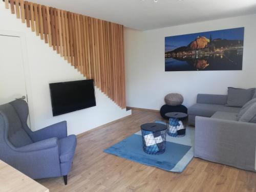 a living room with a couch and a tv at Les hauts de Meez in Dinant