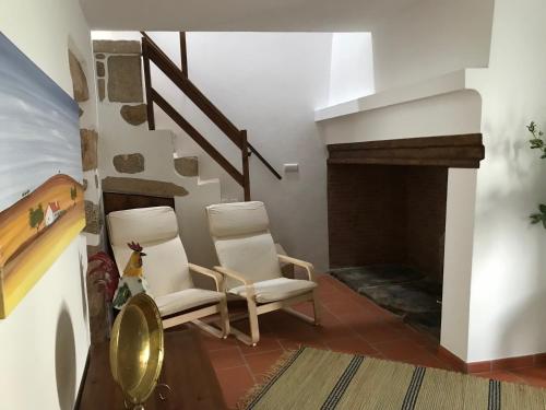 two chairs in a living room with a fireplace at Casa do Ferreiro in Tolosa