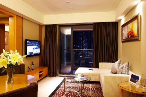 a living room with a couch and a tv at 广州丹顿行政公寓珠江新城店-广交会期间免费穿梭巴士 in Guangzhou