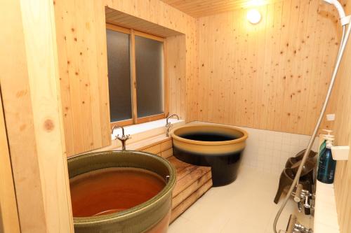 a wooden bathroom with a toilet and a tub at Kyoto Gion No Yado in Kyoto