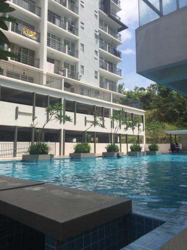 a swimming pool in front of a large building at Spacious & Cozy Condo - Hijauan Heights Block C in Kajang