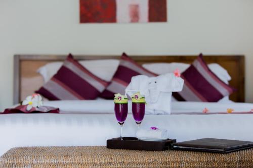 Zimmer mit einem Bett und einem Tisch mit zwei Weingläsern in der Unterkunft Baan Chao Lay in Lipa Noi