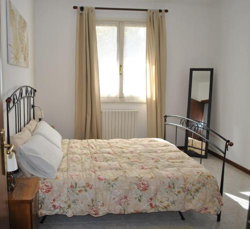 a bedroom with a bed and a window and a mirror at CASA STEFANIA, APPARTAMENTO IN COLLINA in Salsomaggiore Terme