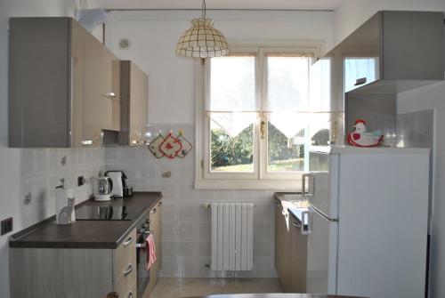 a kitchen with a white refrigerator and a window at Casa Stefania bed&breafast in Salsomaggiore Terme