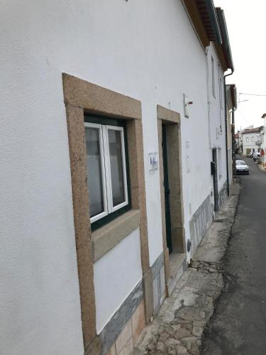 a window on the side of a white building at Casa do Ferreiro in Tolosa