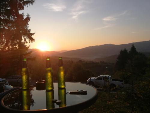 a group of beer bottles sitting on a table with the sunset at Alpina Panoramic in Moisei