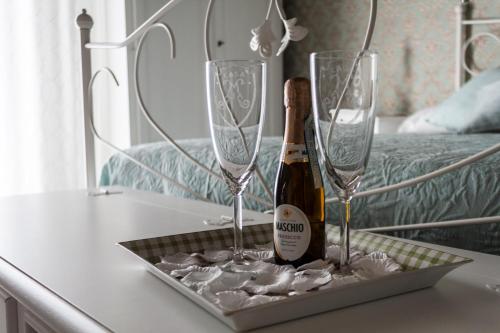 Una botella de champán y dos copas en una mesa. en Casa Maia en Nápoles