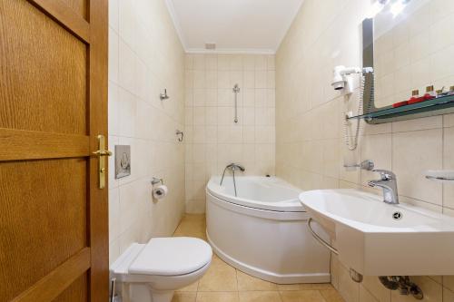 a bathroom with a toilet and a sink and a tub at Pigy in Tatariv