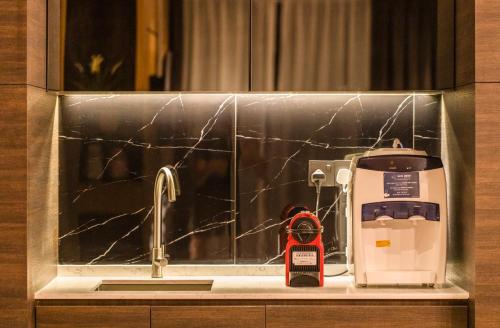 a kitchen counter with a sink with a coffee maker at TROVE Johor Bahru in Johor Bahru