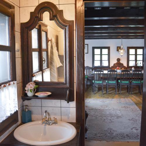 uma casa de banho com um lavatório, um espelho e uma mesa em Vinum Vidae em Lendava