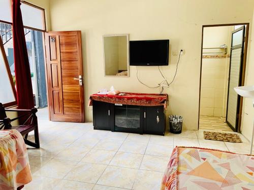 ein Wohnzimmer mit einem TV und einem Kamin in der Unterkunft Sola Gracia Guest House & Kost in Palangkaraya