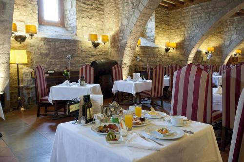 a dining room with two tables with plates of food at Parador de Cardona in Cardona