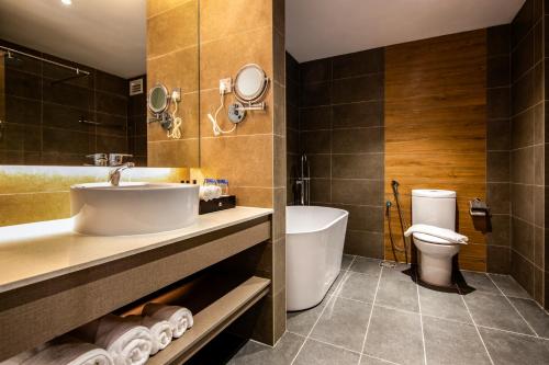 a bathroom with a sink and a tub and a toilet at TROVE Johor Bahru in Johor Bahru