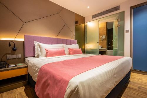 a bedroom with a large bed with pink pillows at TROVE Johor Bahru in Johor Bahru