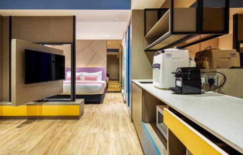a hotel room with a bed and a kitchen at TROVE Johor Bahru in Johor Bahru