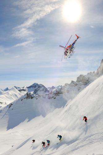 a plane is flying over a snow covered mountain at Burgi's - Adults only in Lech am Arlberg
