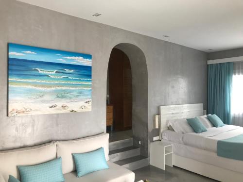 een slaapkamer met een bed en een schilderij van de oceaan bij Melangel in Mykonos-stad