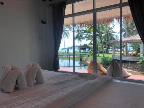 A bed or beds in a room at Prompakdee Kohmak Resort