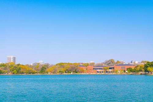 a large body of water with a city in the background at TRIP POD MINOSHIMA A in Fukuoka