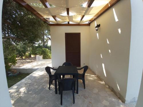 a table and chairs on a patio with a ceiling at Villa del Sole in Manduria