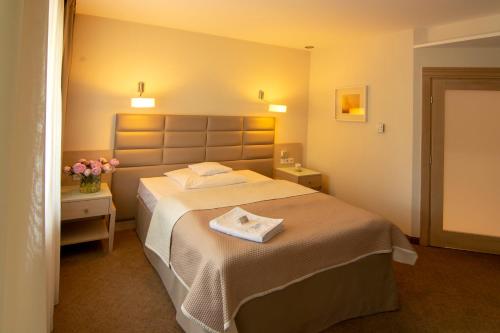 a bedroom with a bed with a towel on it at Columna Medica in Łask