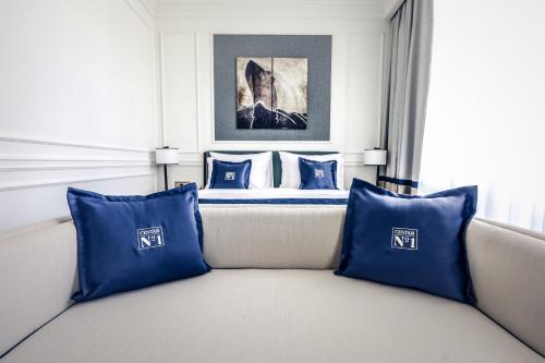a hotel room with a bed with blue pillows at Hotel Centar No.1 in Belgrade