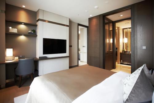 a bedroom with a bed and a desk and a television at Crown Park Hotel Seoul Myeongdong in Seoul