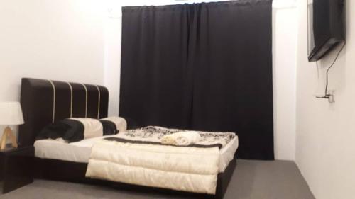 a bedroom with a bed and a black curtain at COMFORTABLE STAY in Ayer Itam