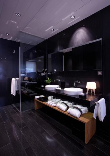 a black bathroom with two sinks and towels at Atrio in Cáceres