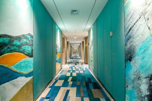 a hallway with blue walls and colorful paintings on the walls at Chengdu Tianfu Sunshine Hotel in Chengdu