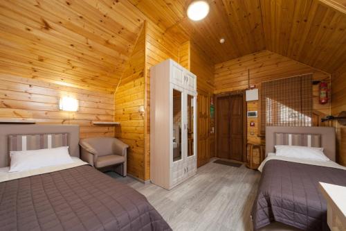 a bedroom with two beds in a wooden cabin at Kompleks Otdykha Elki-Palki in Odesa