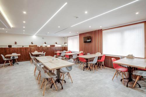 a restaurant with tables and chairs in a room at Orbita Hotel in Saint Petersburg