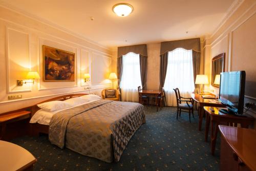 a hotel room with a bed and a flat screen tv at Europe Hotel in Minsk