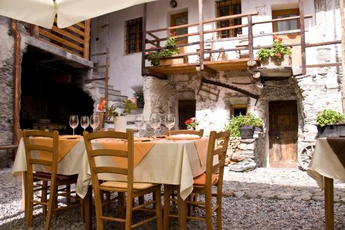 a table with chairs and wine glasses on a patio at Contrada Beltramelli in Villa di Tirano
