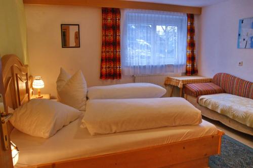 a bedroom with two beds and a couch and a window at Haus Venetblick in Wenns