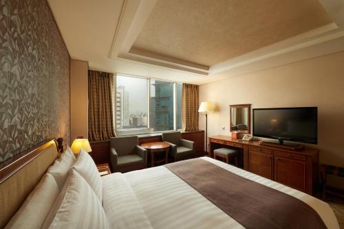 a hotel room with two beds and a television at Seoul Riviera Hotel in Seoul