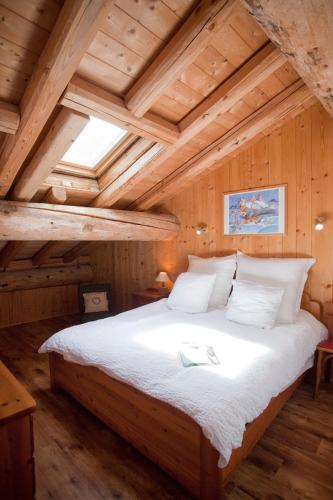 - une chambre avec un grand lit au plafond en bois dans l'établissement Chalet L’Etagne, à Bessans