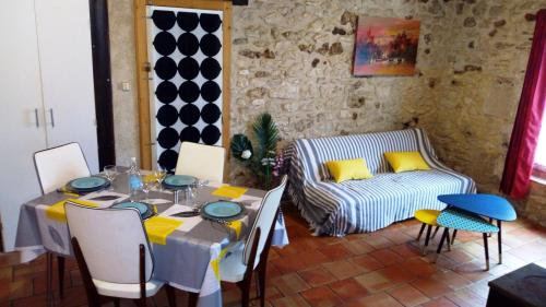 une salle à manger avec une table et un canapé dans l'établissement Maison de campagne en pierres 4 personnes, à Gardonne