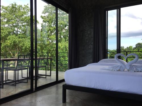a bedroom with a bed with two swans carved into it at ชลลดา ริเวอร์ โฮมสเตย์ แก่งกระจาน in Ban Wang Malako