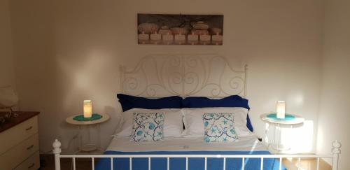 a bedroom with a bed with two candles on two tables at Soluzionestate in Ispica