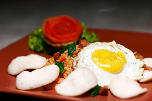 un piatto di cibo con un uovo sopra di Bali Bungalo Hotel a Kuta