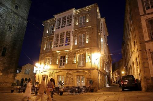 un edificio con gente que pasea por delante de noche en el Hotel Pazo de Altamira de Santiago de Compostela