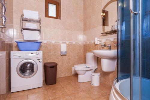 a bathroom with a toilet a sink and a washing machine at Kompleks Otdykha Elki-Palki in Odesa