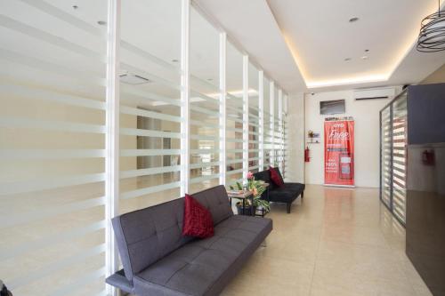 a lobby with a couch and chairs in a building at 18 Suites Cebu in Cebu City