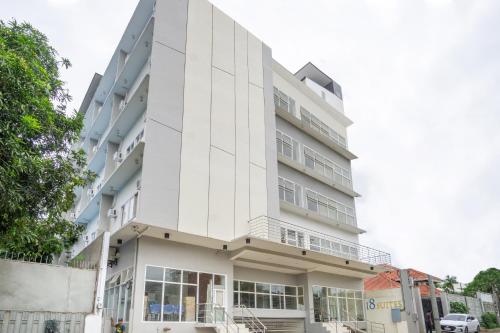a white building with a car parked in front of it at 18 Suites Cebu in Cebu City