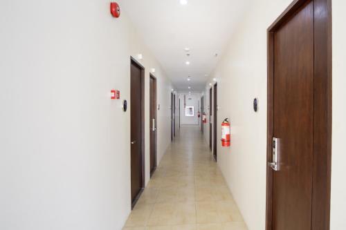 a corridor of a hospital hallway with doors and tile floors at 18 Suites Cebu in Cebu City