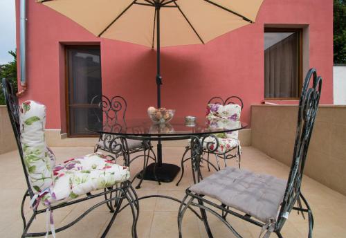 Apartments Nasini في بلوفديف: طاولة وكراسي مع مظلة على الفناء