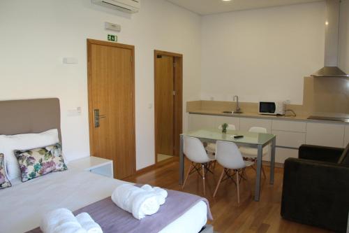 a bedroom with a bed and a table and a kitchen at Hotel Rural da Freita in Arouca
