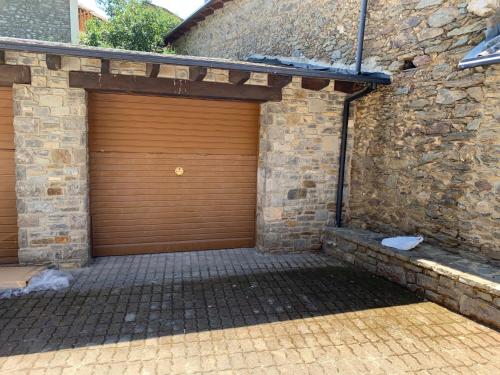 a wooden garage door on a brick building at CAN PLANAS in Urtx